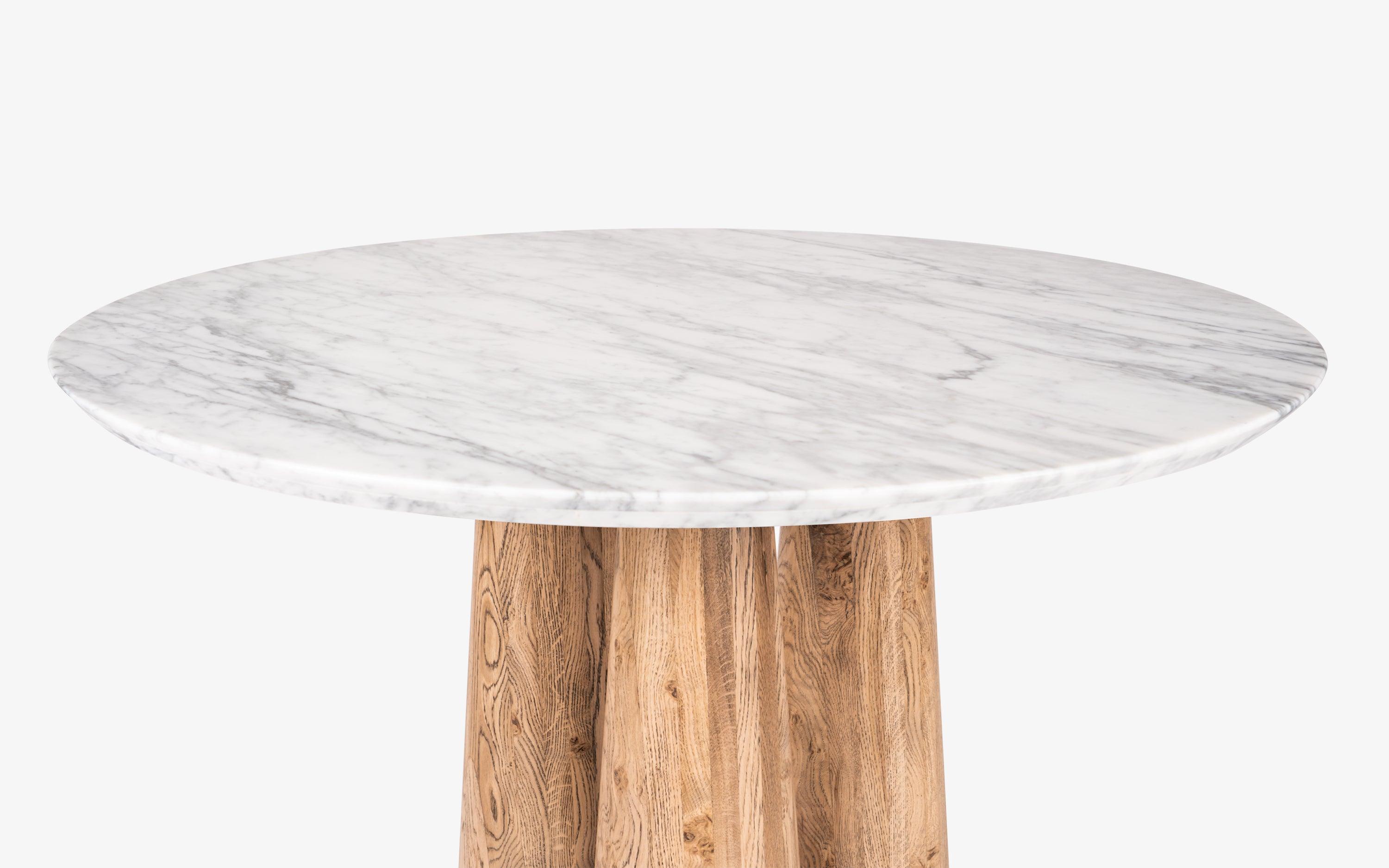 Hump Round Dining Table with Carrara Marble Top and Oak Wood Legs in light brown cerused finish. Luxury marble top dining table for elegant dining rooms.